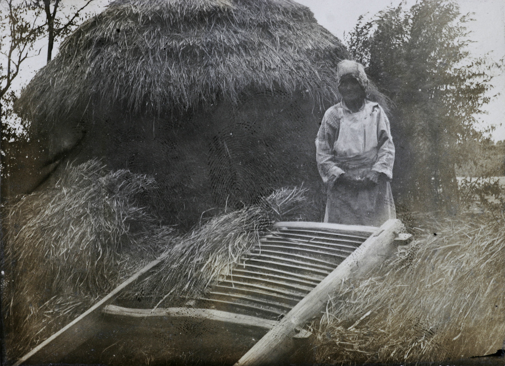 Woman with thresher and haystack