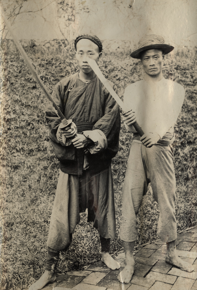 Two executioners of the perpetrators of the ‘Kucheng massacre’, with their weapons