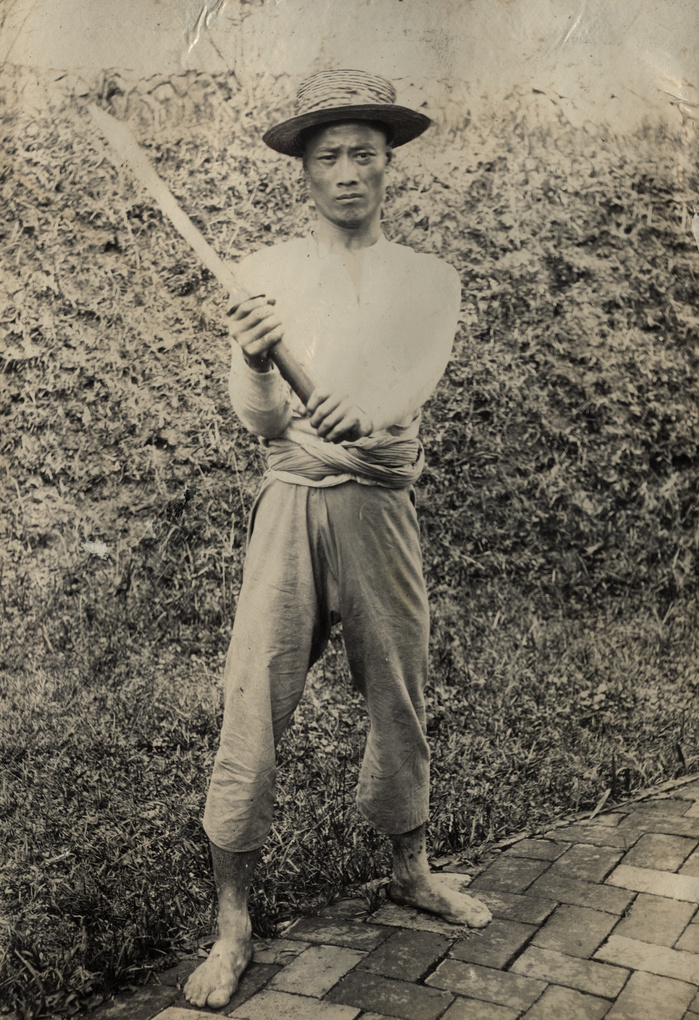 One of the executioners of the perpetrators of the ‘Kucheng massacre’, with his weapon