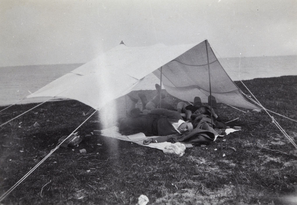 Hikers resting in a tent beside the Huangpu River, near Shanghai