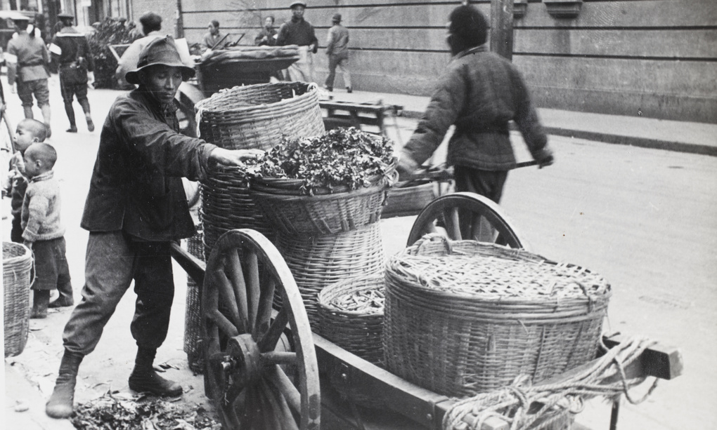 Food market trader with cart and baskets of produce