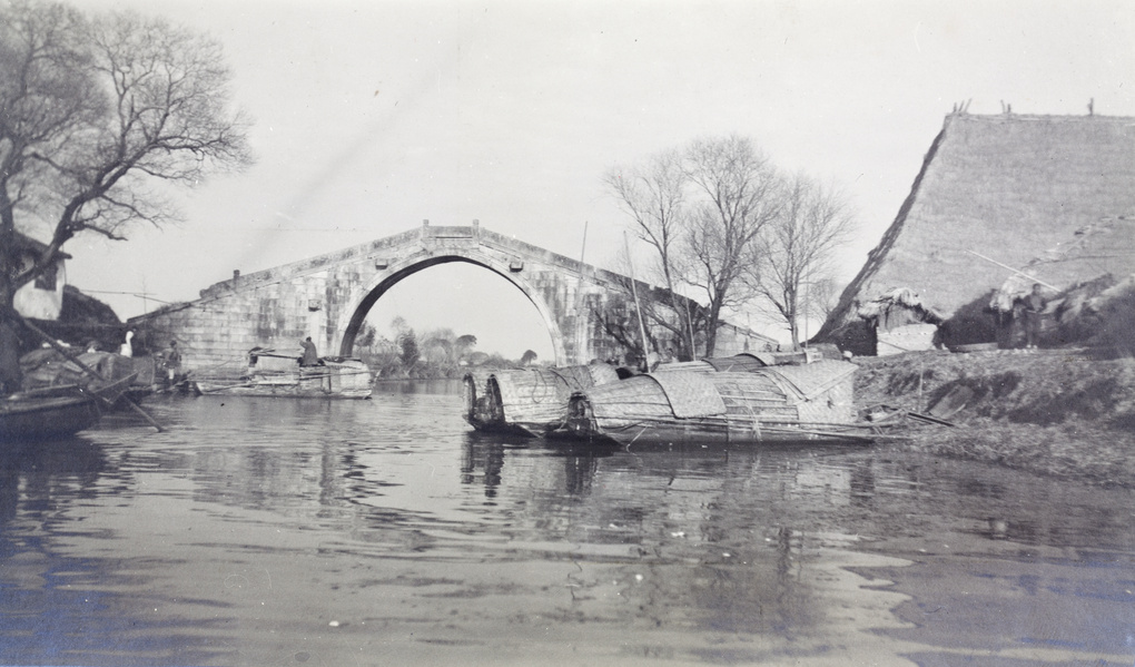 Sampans moored near a bridge and an icehouse