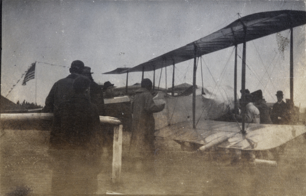 Katherine Stinson with crew, reporters, and soldiers around her airplane, Jiangwan airfield, Shanghai