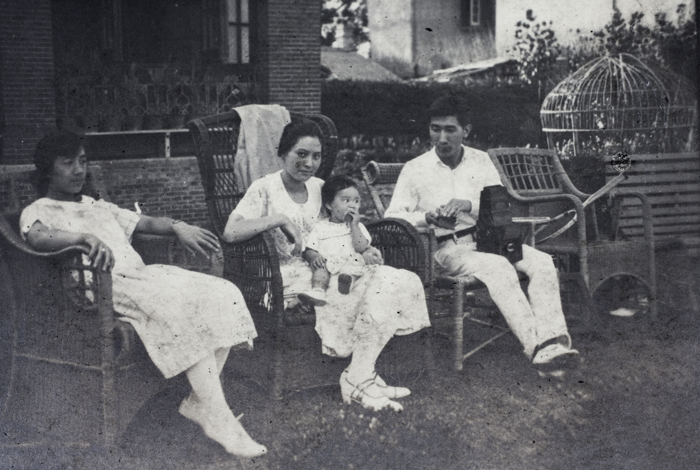 Maggie, Sarah, Bea, and Tom Hutchinson (with film holder and camera), in the garden, 35 Tongshan Road, Hongkou, Shanghai