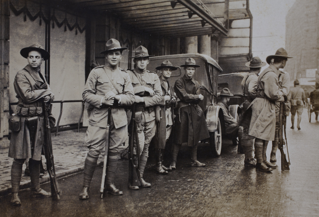 American Company Shanghai Volunteer Corps members on guard duty with rifles outside Wing-on Department Store, Shanghai, 1925