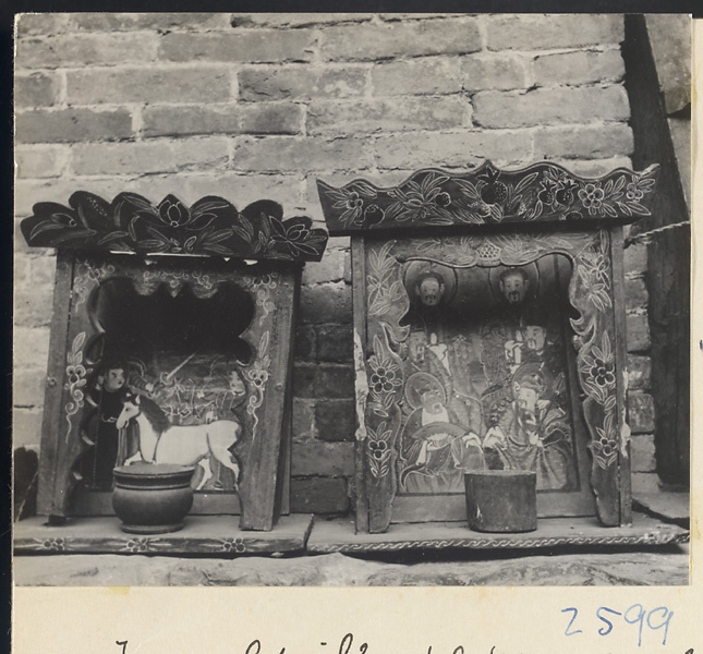 Two small carved wooden shrines painted with figures, a horse, and floral motifs