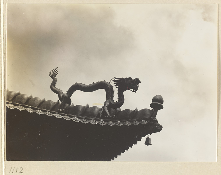 Detail showing double-eaved roof of Miao gao zhuang yan dian with a dragon and a bell