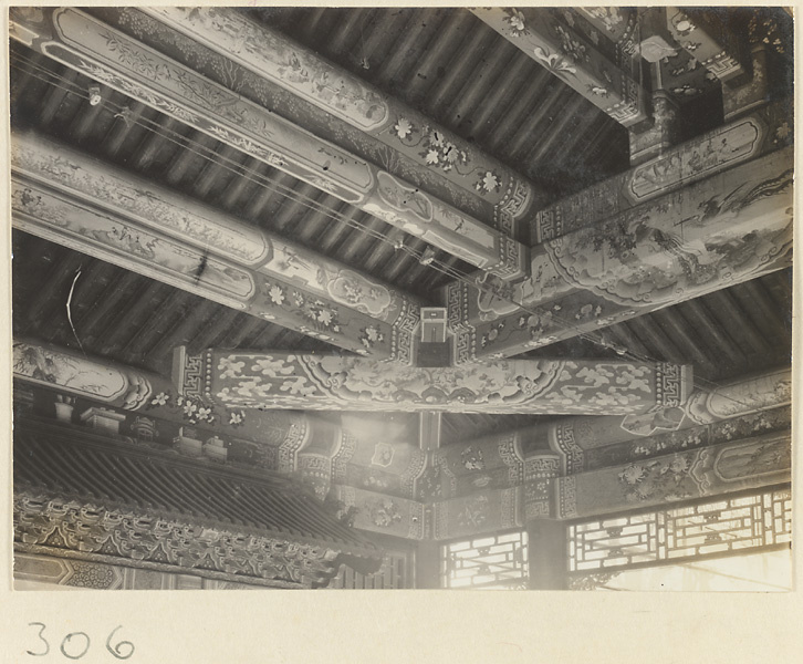 Building interior at Yihe Yuan showing roof beams painted with landscape scenes and floral and cloud motifs