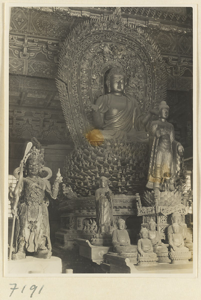 Interior of a temple building at Jie tai si showing altar with a Buddha on a lotus throne and other statues