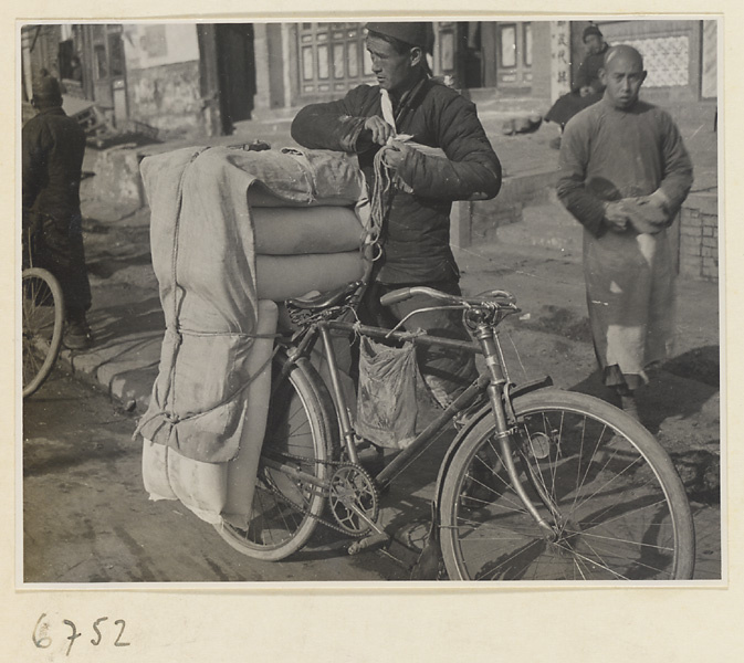 Man loading sacks onto a bicycle