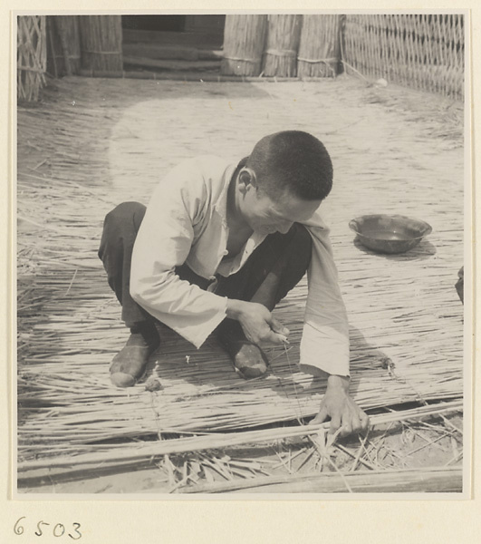 Man weaving a mat at a mat-making shop