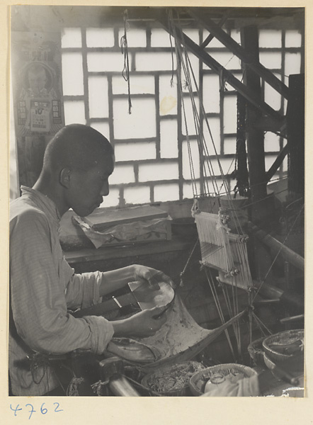 Man at a loom weaving anklebands