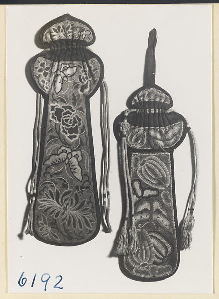 Two pipe bags embroidered with floral, butterfly, and lantern motifs