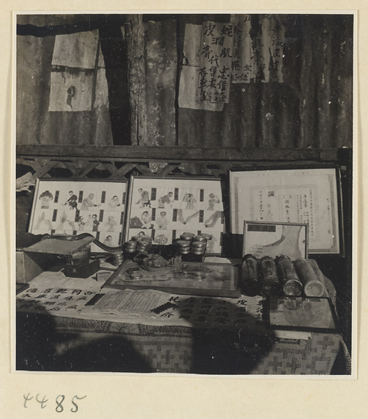 Street doctor's stand showing snake, medicines, and posters picturing ailments