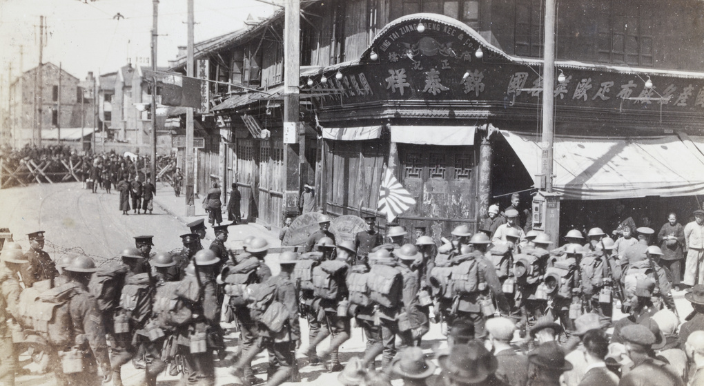 British soldiers marching past barricaded street, Shanghai
