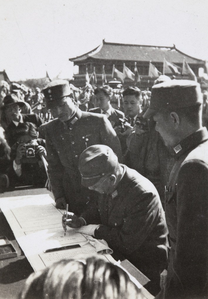 Hiroshi Nemoto signing Japanese surrender documents, 10 October 1945