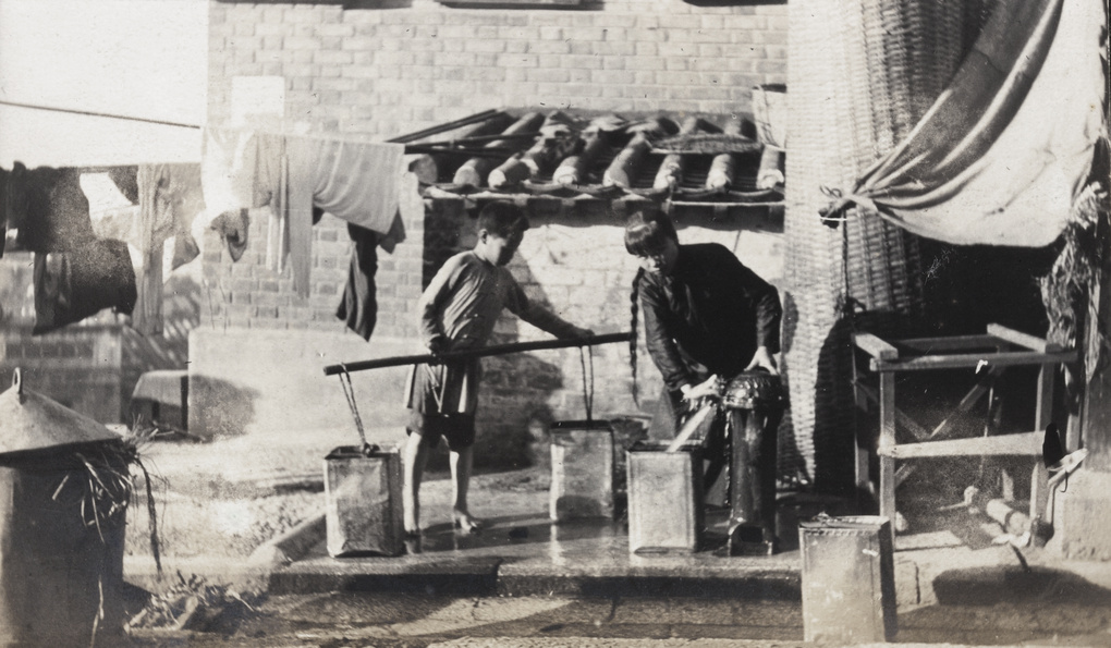 Two children collecting water at a pump, Hong Kong