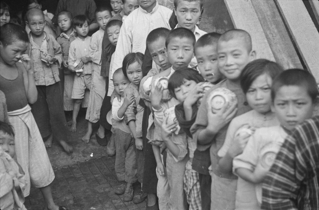 Children and adults queuing, with rice bowls, Shanghai