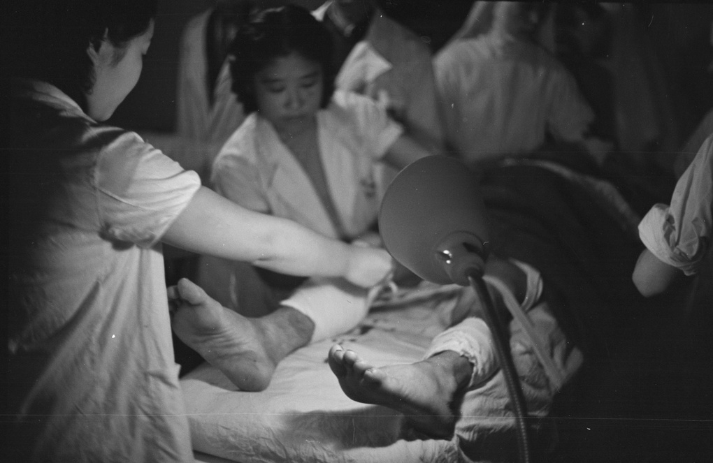 Nurses bandaging a patient's leg, Shanghai