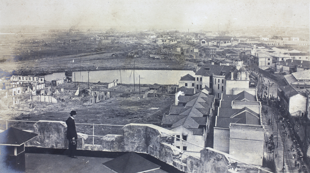A photographer on the Water Tower, Hankow, with ruins behind