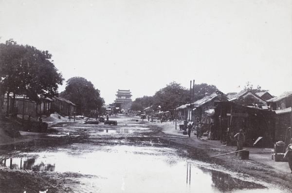 A city gate-tower and muddy street, Beijing