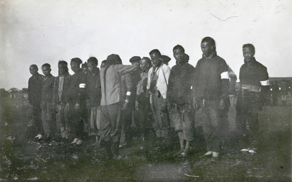 Line up of men with white armbands