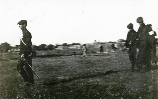 Men with white armbands and an officer