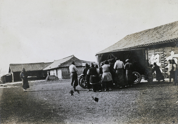 Crowd gathered around an automobile