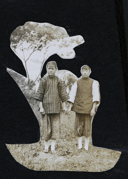 Two girls beside a tree