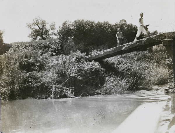 Children crossing a stone beam bridge