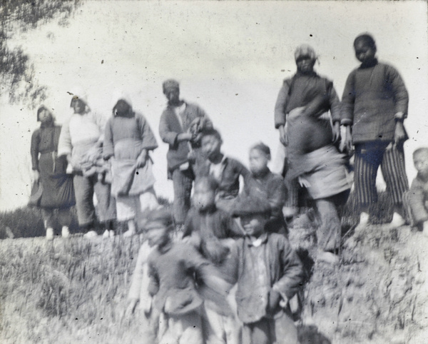 Women and children beside a pit