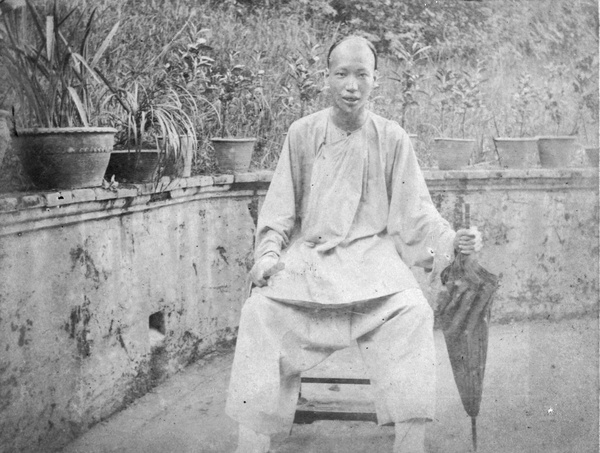 Chinese man with umbrella and fan