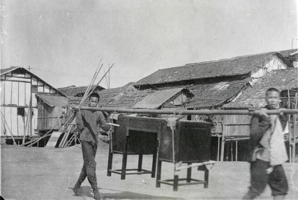 Bearers carrying a piece of furniture