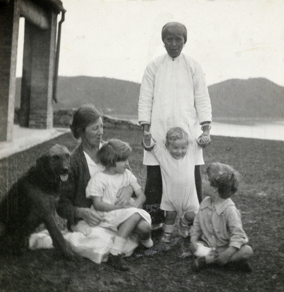 Family and Chinese nursemaid outside bungalow