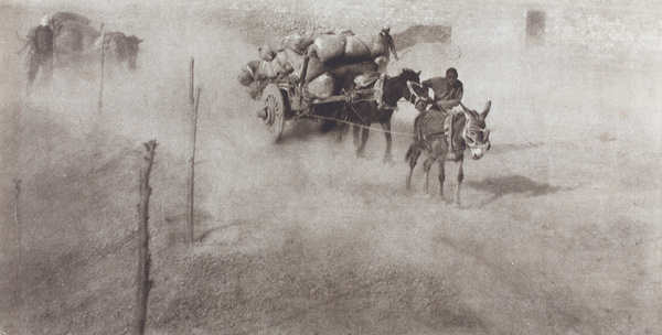 Carters guide goods carts along dusty road, Peking