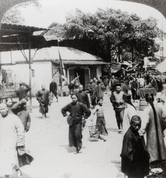 A street scene in Guangzhou (广州), including a child walking a pet bird