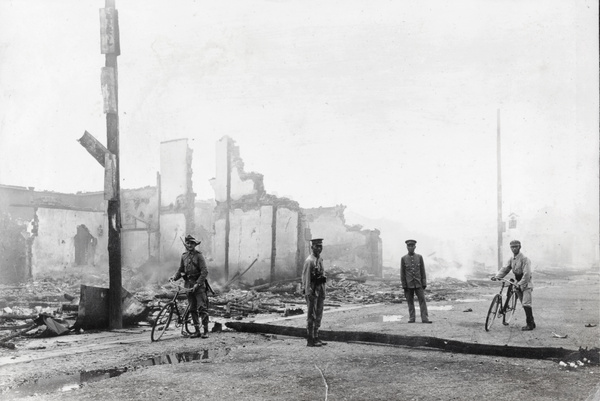 Foreign and Chinese soldiers beside fallen telegraph pole, Hankow