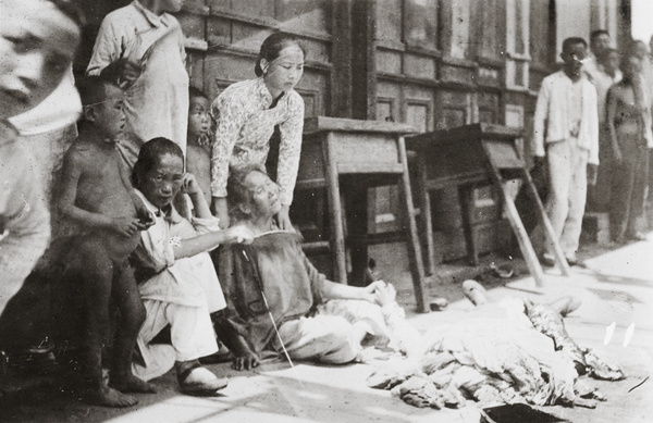 A woman grieves, beside a dead man, Hankow