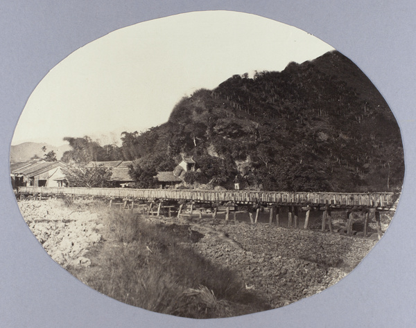 A man standing on a wood and bamboo aqueduct, Taipei, Taiwan