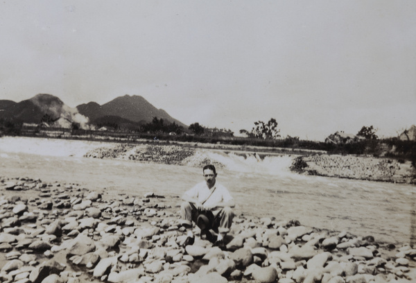 Mr Jensen sitting on stones by a river