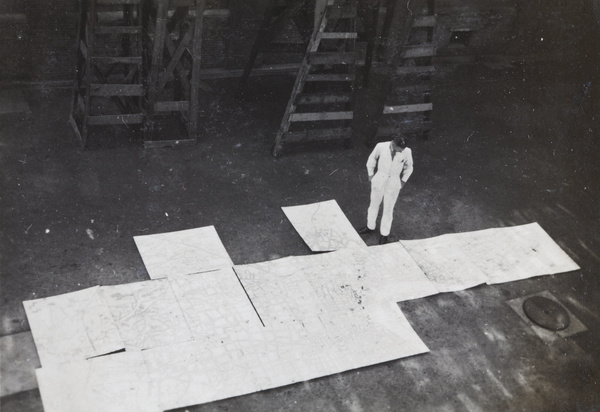 Mr Pulman looking at a very large map of Shanghai assembled on the printing factory floor, Shanghai