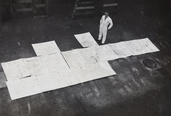 Mr Pulman with a very large map of Shanghai assembled on the printing factory floor, Shanghai