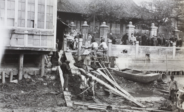 Watching workers clearing muck from a river bed