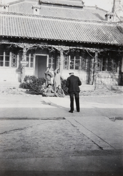 A photographer taking a group portrait outside a barber’s shop