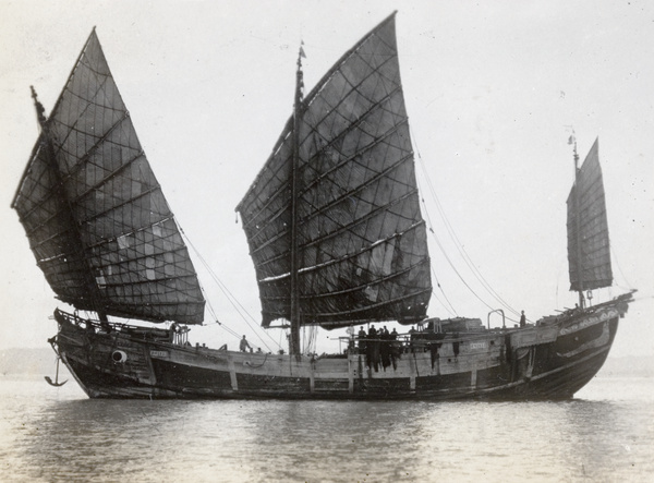 A becalmed junk in full sail, arranged for the photographer