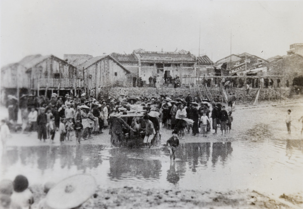 People in a fishing village watching men carrying the wayward torpedo