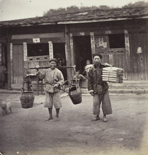 Two men: one carrying pails, one carrying folded felt/textiles