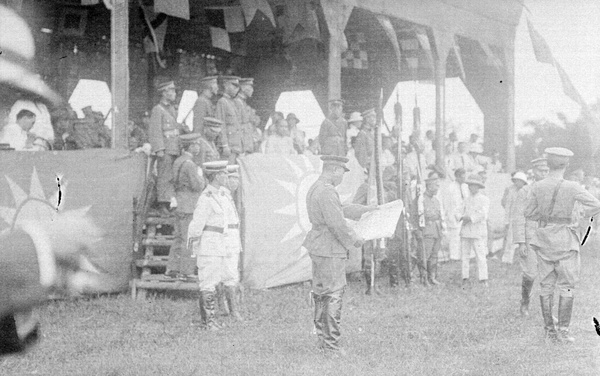 Man reading a proclamation at a Nationalist Party rostrum