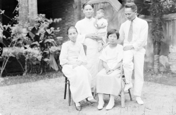 A group posed in a garden, with a child