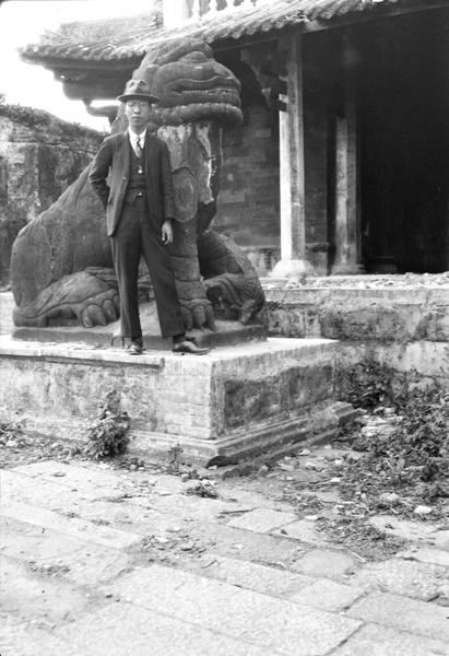 A young man by a stone guardian lion (shishi 石獅)